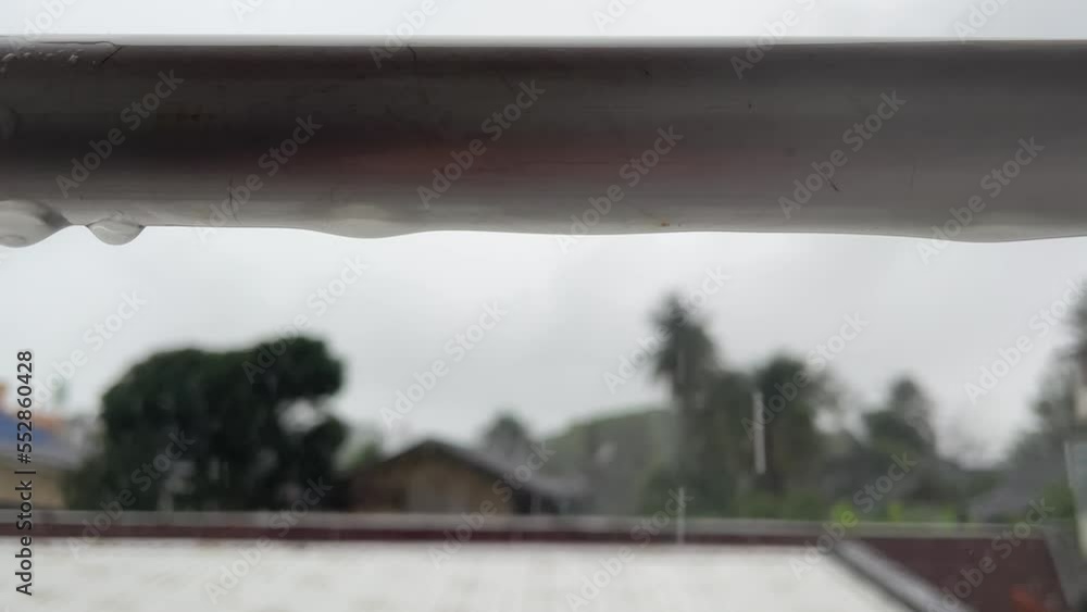 Rain drop on silver pole with tree in background. Droplet of water drip from the pole. Hua Hin, Thailand Rain drop on silver pole with tree in background. Droplet of water drip from the pole. Hua Hin, Thailand