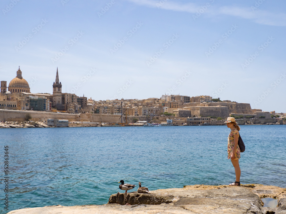 Tourist on the a rocky coast with coves and turquoise waters in Malta. Europe Sliema coastline in Malta, Europe.