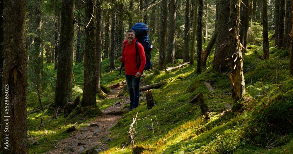 Tourist guy with backpack hiking on an adventure trip in natural landscape