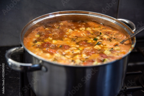 gotująca sie supa toskańska w dużym garnku stalowym photo