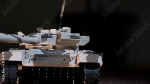 Close-up shot of an isolated radio-controlled toy tank that drives, rotates the turret and fires from the muzzle. Military children's toys. A game of war games with heavy weapons. RC toy tank
