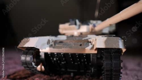 Close-up shot of an isolated radio-controlled toy tank that drives, rotates the turret and fires from the muzzle. Military children's toys. A game of war games with heavy weapons. RC toy tank
