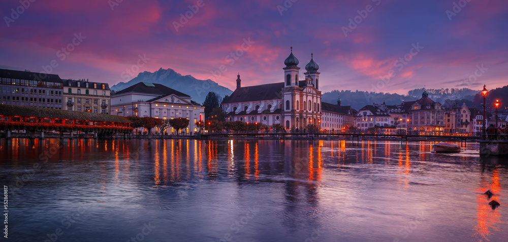 Scenic evening panorama view of the Old Town medieval architecture in Lucerne, Switzerland. Dramatic scene with Reuss river and Jesuit church. Wonderful vivid cityscape during sunset