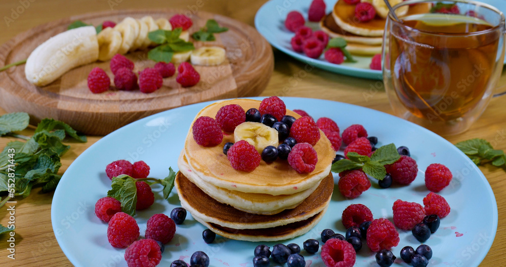 Pancakes with raspberry, banana and a mint leaf