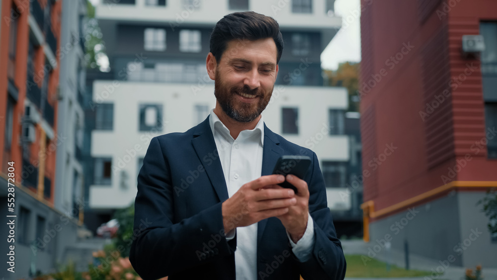 Successful businessman caucasian bearded man employee manager use internet city wifi chatting messages online point finger on modern phone making thumb up approval gesture enjoy cell mobile connection Successful businessman caucasian bearded man employee manager use internet city wifi chatting messages online point finger on modern phone making thumb up approval gesture enjoy cell mobile connection