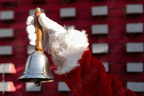Close-up of a Santa hand holding a Christmas bell