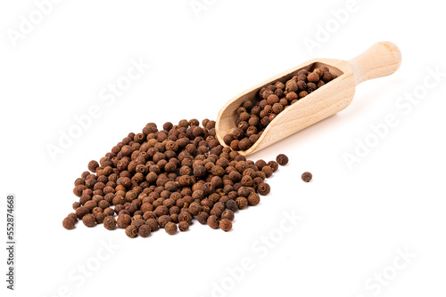 Pepper allspice on wooden spoon isolated on white background.