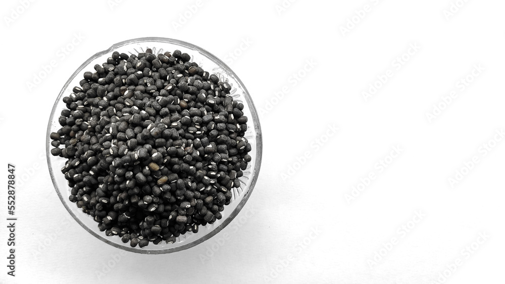Black moong, mung or whole black urad beans in a glass bowl isolated on white background. Copy space Black moong, mung or whole black urad beans in a glass bowl isolated on white background. Copy space