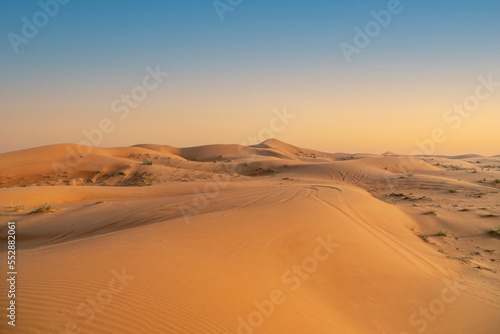 Beautiful view to group of sand dunes in the desert and blue sky over horizon. Amazing outdoor adventure. 