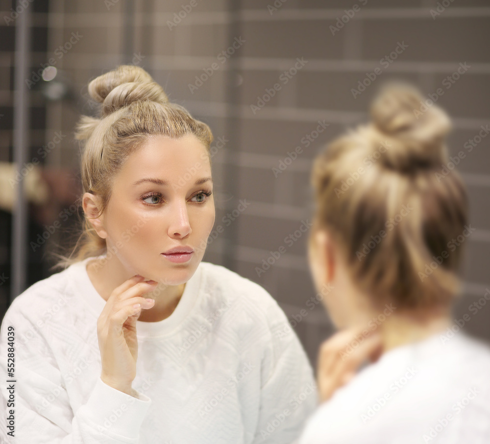 Woman looking in the mirror Applying the cream..Magic anti-aging cream Woman looking in the mirror Applying the cream..Magic anti-aging cream
