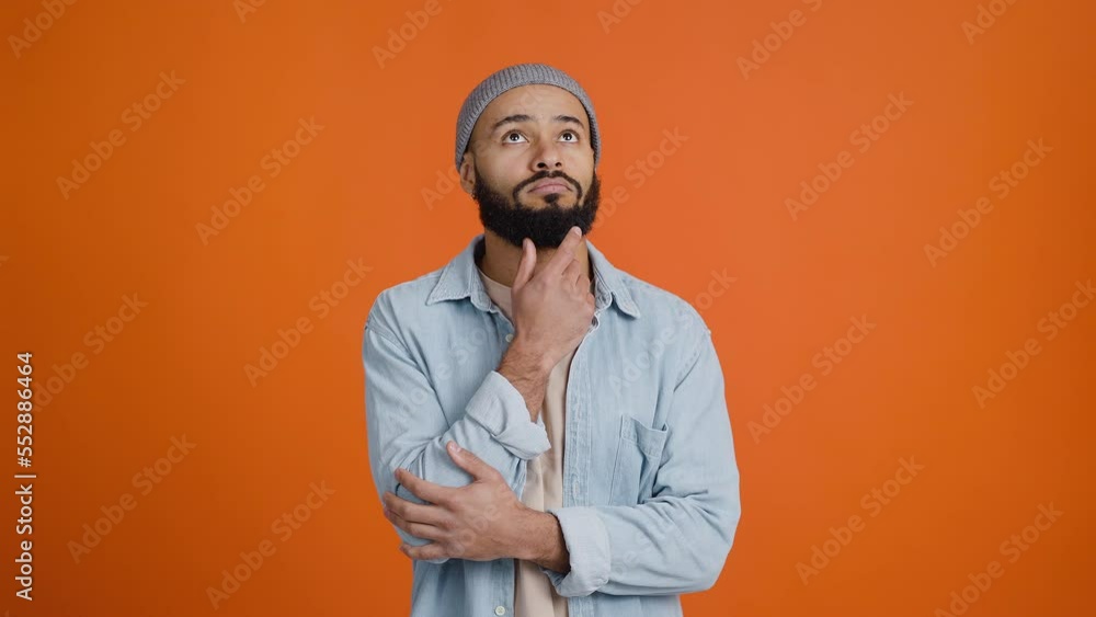 African American man rubs beard with fingers thoughtfully African American man rubs beard with fingers thoughtfully