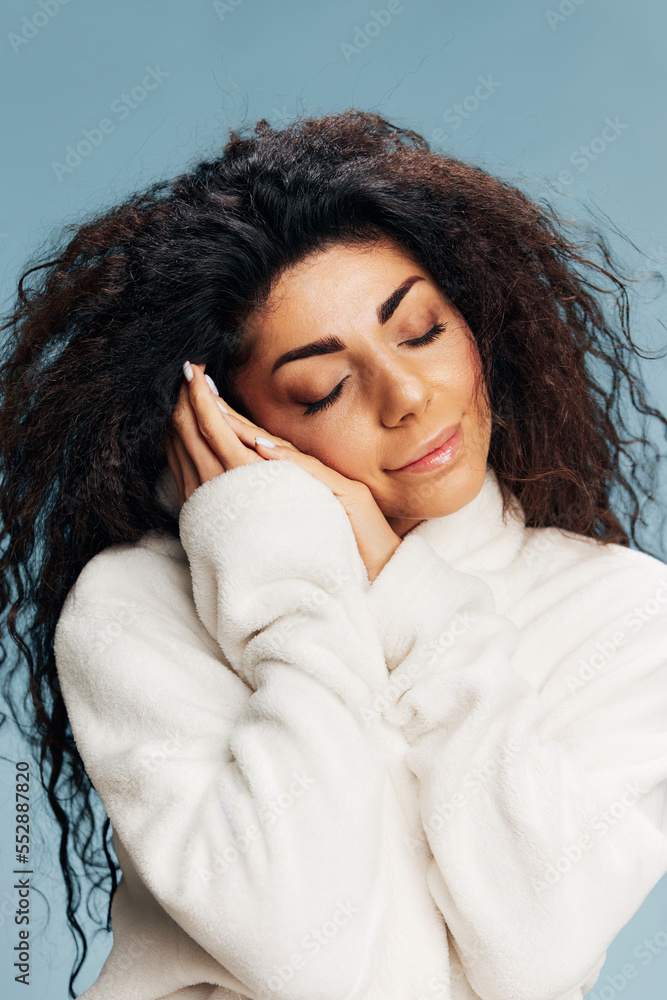 SPA PROCEDURE CONCEPT. Smiling happy curly Latin lady enjoy soft bathrobe touching face, recline on hands, sleeping, posing isolated on pastel blue background, closing eyes. Copy space, beauty banner SPA PROCEDURE CONCEPT. Smiling happy curly Latin lady enjoy soft bathrobe touching face, recline on hands, sleeping, posing isolated on pastel blue background, closing eyes. Copy space, beauty banner