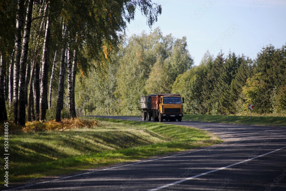 A sharp turn, a beautiful country road with a truck far A sharp turn, a beautiful country road with a truck far