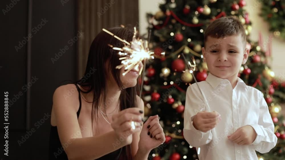 Mom with son a sparkler holder.Christmas celebration. Mom with son a sparkler holder.Christmas celebration.