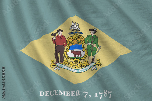 Delaware US state flag with big folds waving close up under the studio light indoors. The official symbols and colors in fabric banner photo