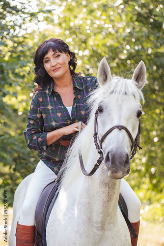 beautiful woman riding a white horse