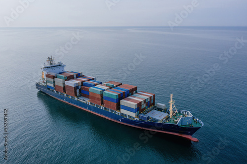 Cargo ship with containers in the open sea, aerial drone view
