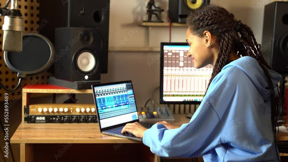 Sound engineer using control desk recording new track for album in soundproof room of music studio Sound engineer using control desk recording new track for album in soundproof room of music studio