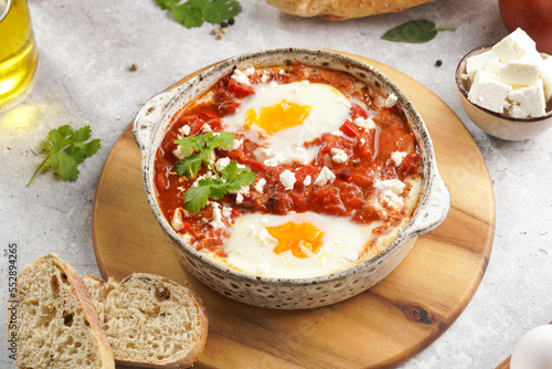 Traditional north african dish shakshouka made of eggs poached in a sauce of tomatoes, olive oil, bell peppers, onion and garlic, spiced with cumin, paprika and cayenne pepper