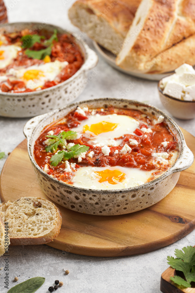 Traditional north african dish shakshouka made of eggs poached in a sauce of tomatoes, olive oil, bell peppers, onion and garlic, spiced with cumin, paprika and cayenne pepper