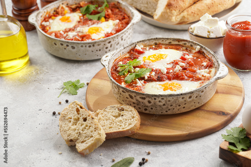 Traditional north african dish shakshouka made of eggs poached in a sauce of tomatoes, olive oil, bell peppers, onion and garlic, spiced with cumin, paprika and cayenne pepper Traditional north african dish shakshouka made of eggs poached in a sauce of tomatoes, olive oil, bell peppers, onion and garlic, spiced with cumin, paprika and cayenne pepper