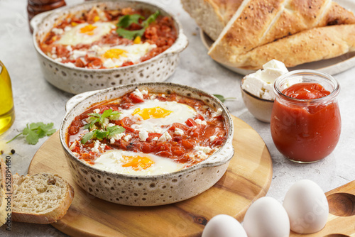 Traditional north african dish shakshouka made of eggs poached in a sauce of tomatoes, olive oil, bell peppers, onion and garlic, spiced with cumin, paprika and cayenne pepper