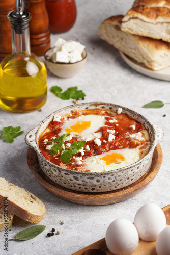 Traditional north african dish shakshouka made of eggs poached in a sauce of tomatoes, olive oil, bell peppers, onion and garlic, spiced with cumin, paprika and cayenne pepper