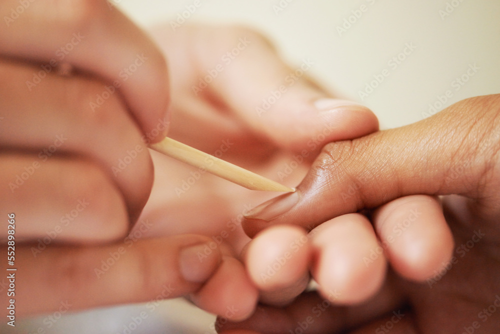 Working magic on her nails. Cropped shot of a woman getting a manicure. Working magic on her nails. Cropped shot of a woman getting a manicure.