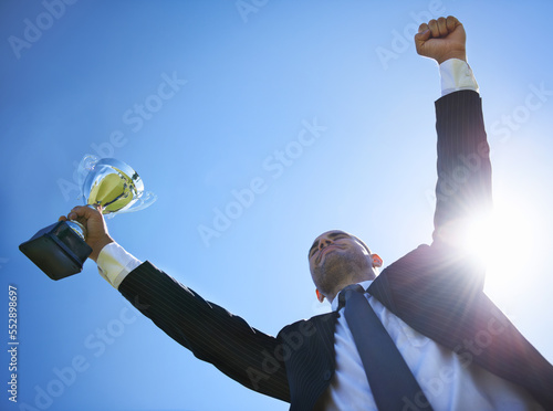 Corporate success. Low angle view of a businessman holding a cup. © Mikolette M/peopleimages.com