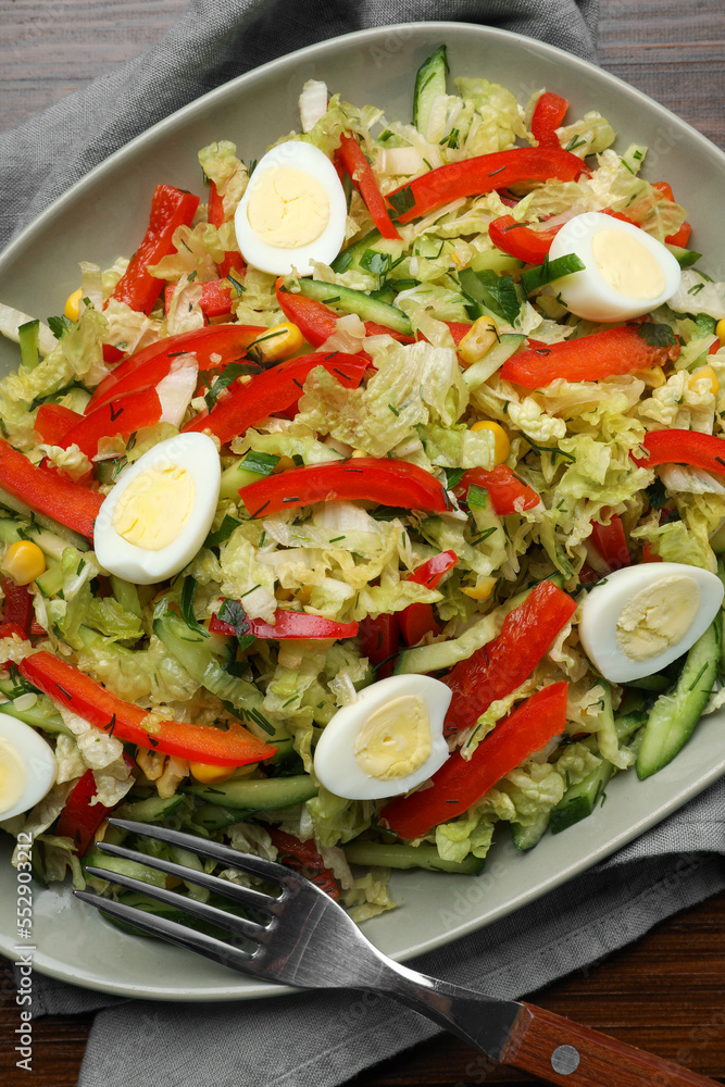 Delicious salad with Chinese cabbage and quail eggs served on wooden table, top view Delicious salad with Chinese cabbage and quail eggs served on wooden table, top view