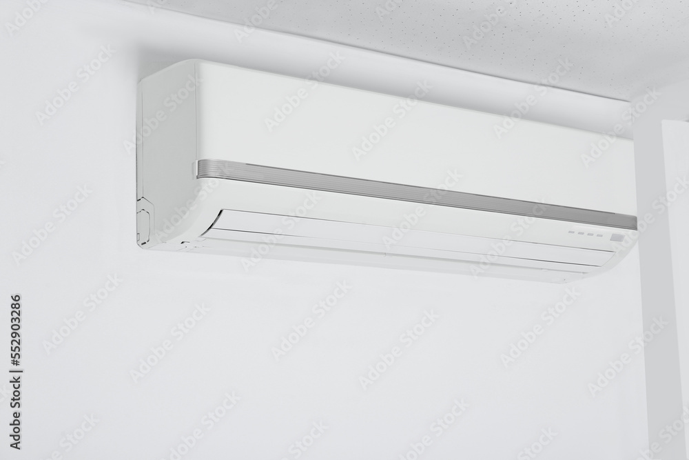 Modern air conditioner hanging on white wall Modern air conditioner hanging on white wall