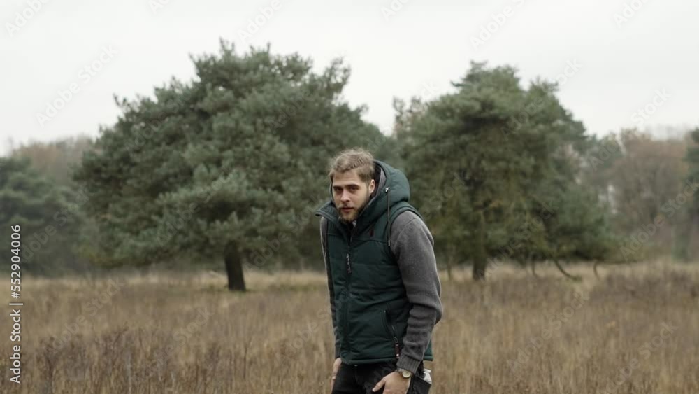 Man standing alone in a field in the middle of the forest. Man standing alone in a field in the middle of the forest.