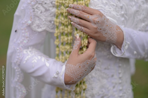 jasmine flowers as decoration at wedding in indonesia, holding by bride hands with white henna