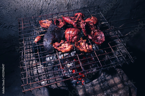 The offal is grilled on a grill over a hot fire. photo