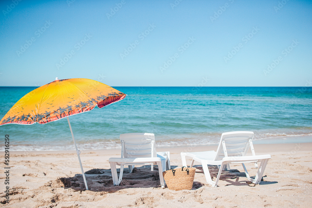 Beach sun beds and umbrella on white beach