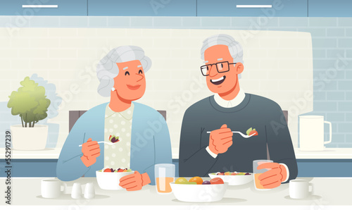 Elderly couple is having breakfast at the table in the kitchen. Happy seniors eat tasty and healthy food. Grandma and Grandpa are having lunch