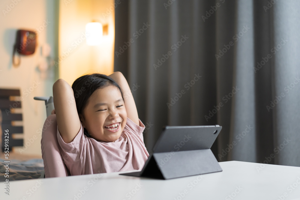 asian child smile learning on computer tablet or kid girl student enjoy fun to study online class or person happy learn from home school by video call studying technology education on pad in bedroom asian child smile learning on computer tablet or kid girl student enjoy fun to study online class or person happy learn from home school by video call studying technology education on pad in bedroom