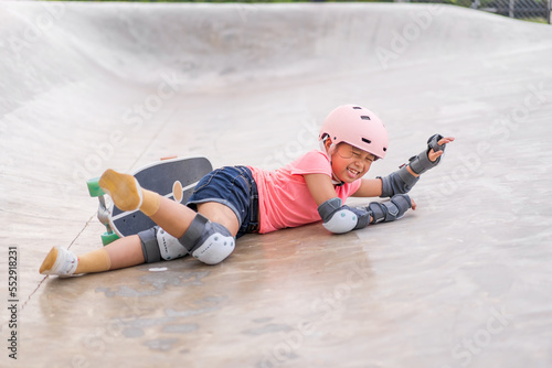 Bilde på lerret asian child or kid girl ride skateboard or surf skate and slipping fall to fail