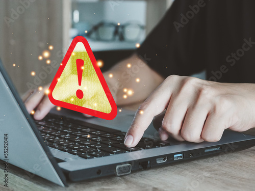 Fototapeta Naklejka Na Ścianę i Meble -  Male hand working through laptop and receiving warning triangle sign for error notification and maintenance concept. Document error display cyber attack