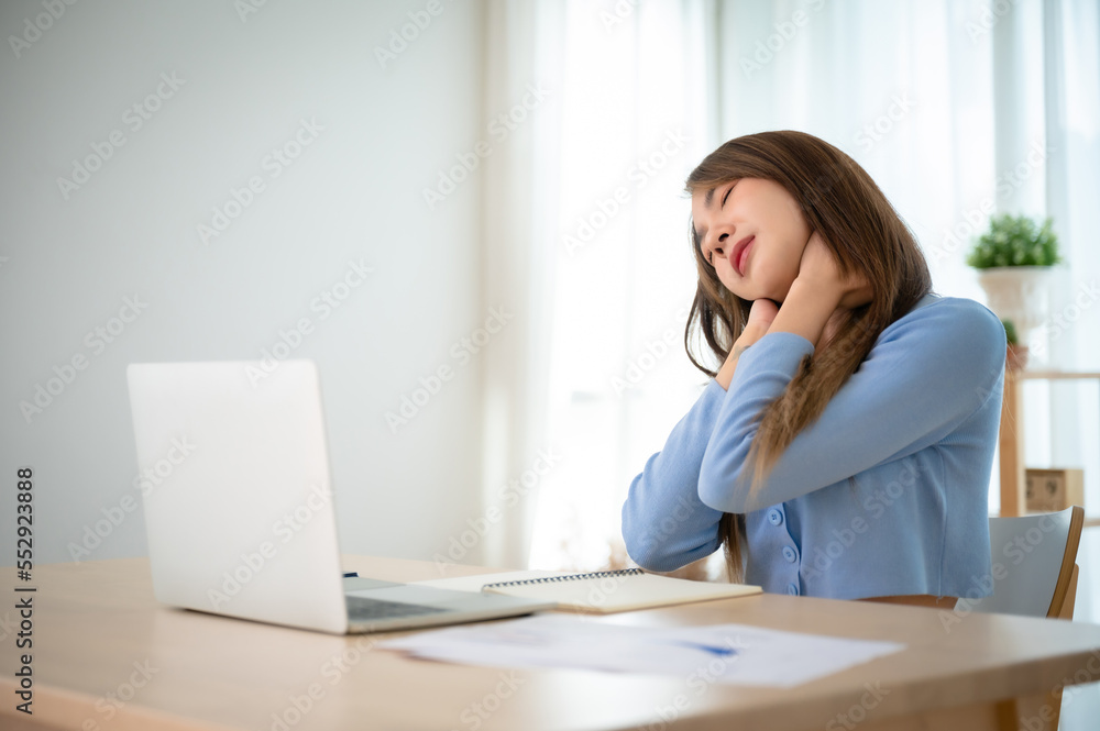 Office syndrome concept. Young asian woman feeling pain in neck and shoulder after working on computer laptop for a long time. She stretches to relax her muscles Office syndrome concept. Young asian woman feeling pain in neck and shoulder after working on computer laptop for a long time. She stretches to relax her muscles