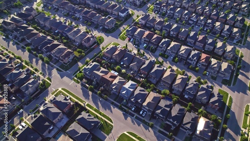 Aerial view of American suburban neighbourhood. Residential single American family houses. North America suburb streets. Established Real estate at golden hour sunset with long shadows.