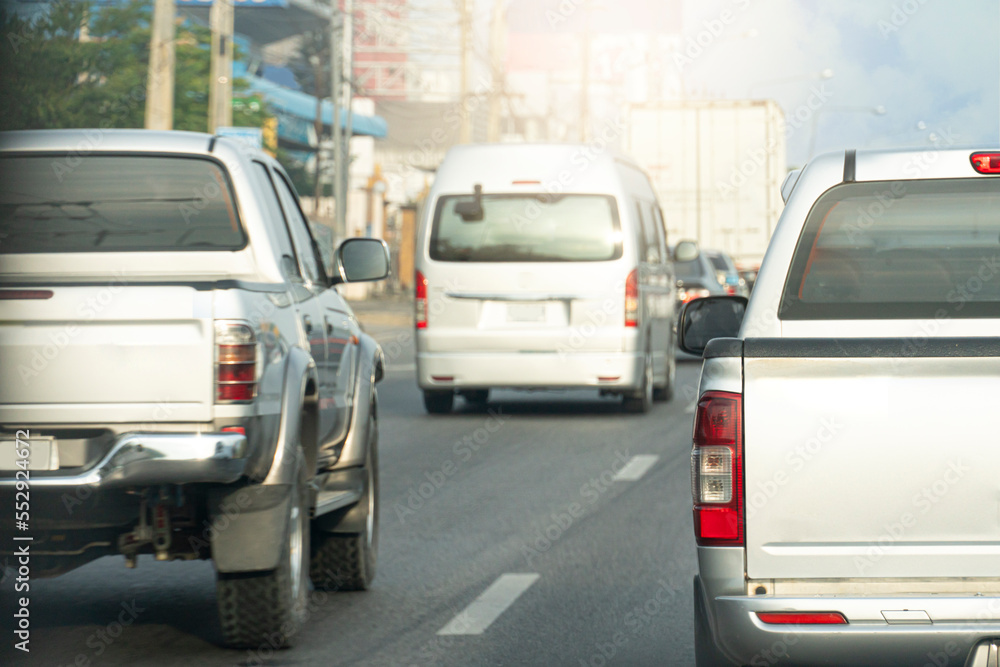 Rear side of pickup silver color driving on the asphalt road. Drive in the business time or trip to travel. Environment in the city.