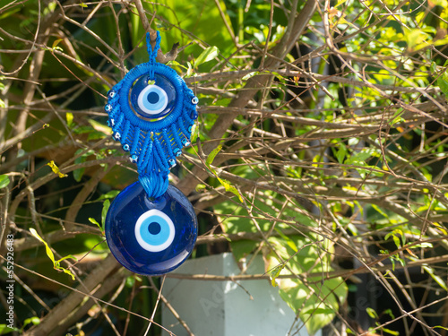 Close up of evil eye charms hang from a tree.