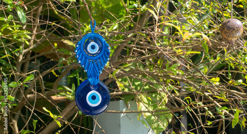 Close up of evil eye charms hang from a tree.