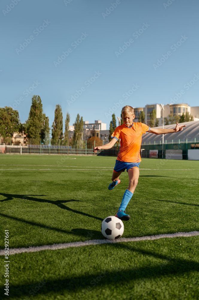 Young soccer goalie starting game kicking ball from white goal line