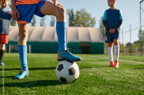 Young soccer player holding boots on ball cropped shot