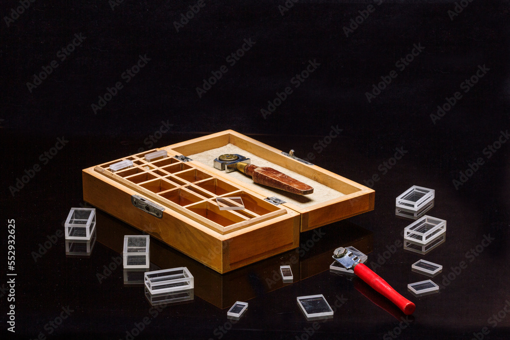 manual glass cutter, diamond-coated cutting roller, on a black background with glass figures. manual glass cutter, diamond-coated cutting roller, on a black background with glass figures.