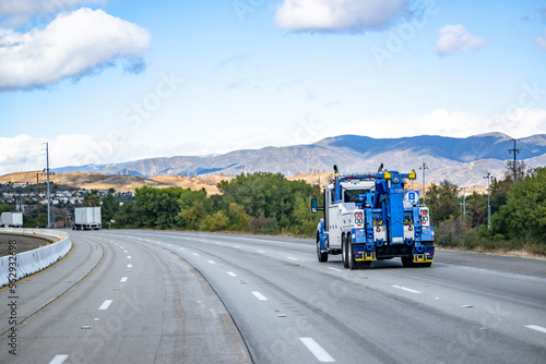 Wallpaper Mural Powerful big rig towing semi truck tractor with lifting boom running on the wide highway road to help a semi truck in an accident Torontodigital.ca
