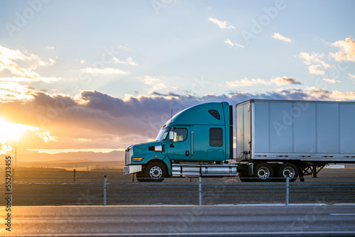 Foto Streamline green big rig bonnet semi truck transporting cargo in dry van semi tr