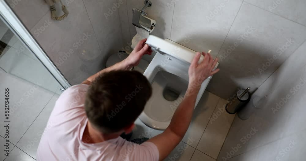 Man on his knees in bathroom vomits into toilet Man on his knees in bathroom vomits into toilet